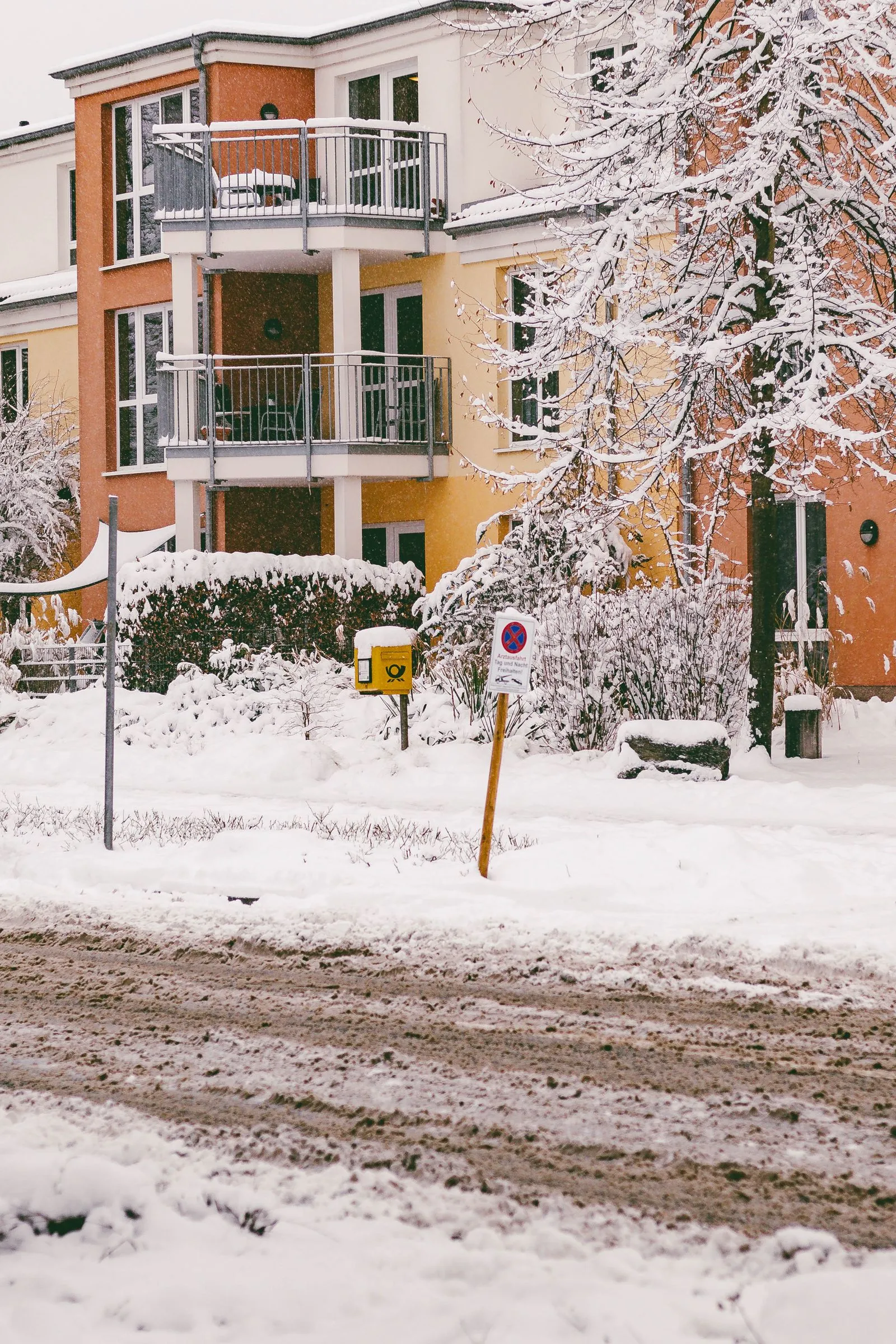 Verschneite Wohnanlage mit Balkonen an einem Wintertag.