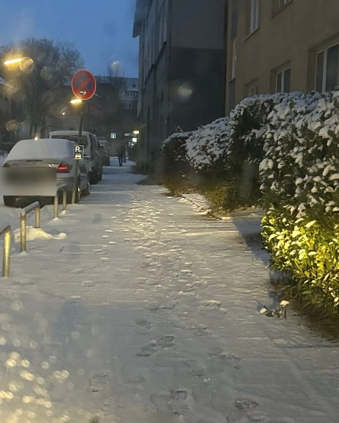 Verschneiter Gehweg an einer Hamburger Wohnstraße vor dem Winterdienst-Einsatz.